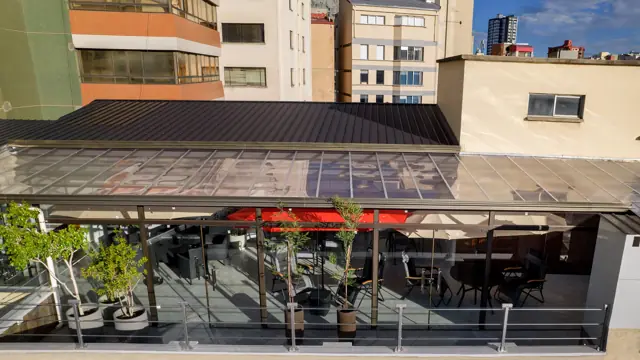 La terraza vista desde arriba, con su techo vidriado y plantas en el borde