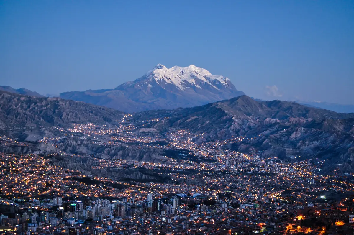 La Paz al anochecer, con las luces de la ciudad y el Illimani nevado de fondo