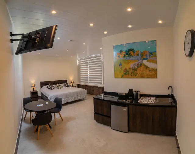 Suite con cama doble, mesa y kitchenette